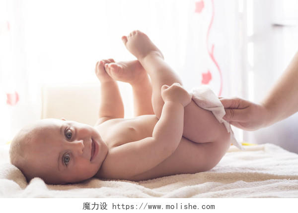 卫生年轻的妈妈用湿纸巾擦拭婴儿皮肤微笑的小孩婴儿微笑